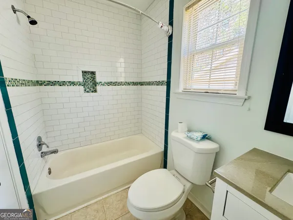 a bath room with a toilet a sink and a bath tub