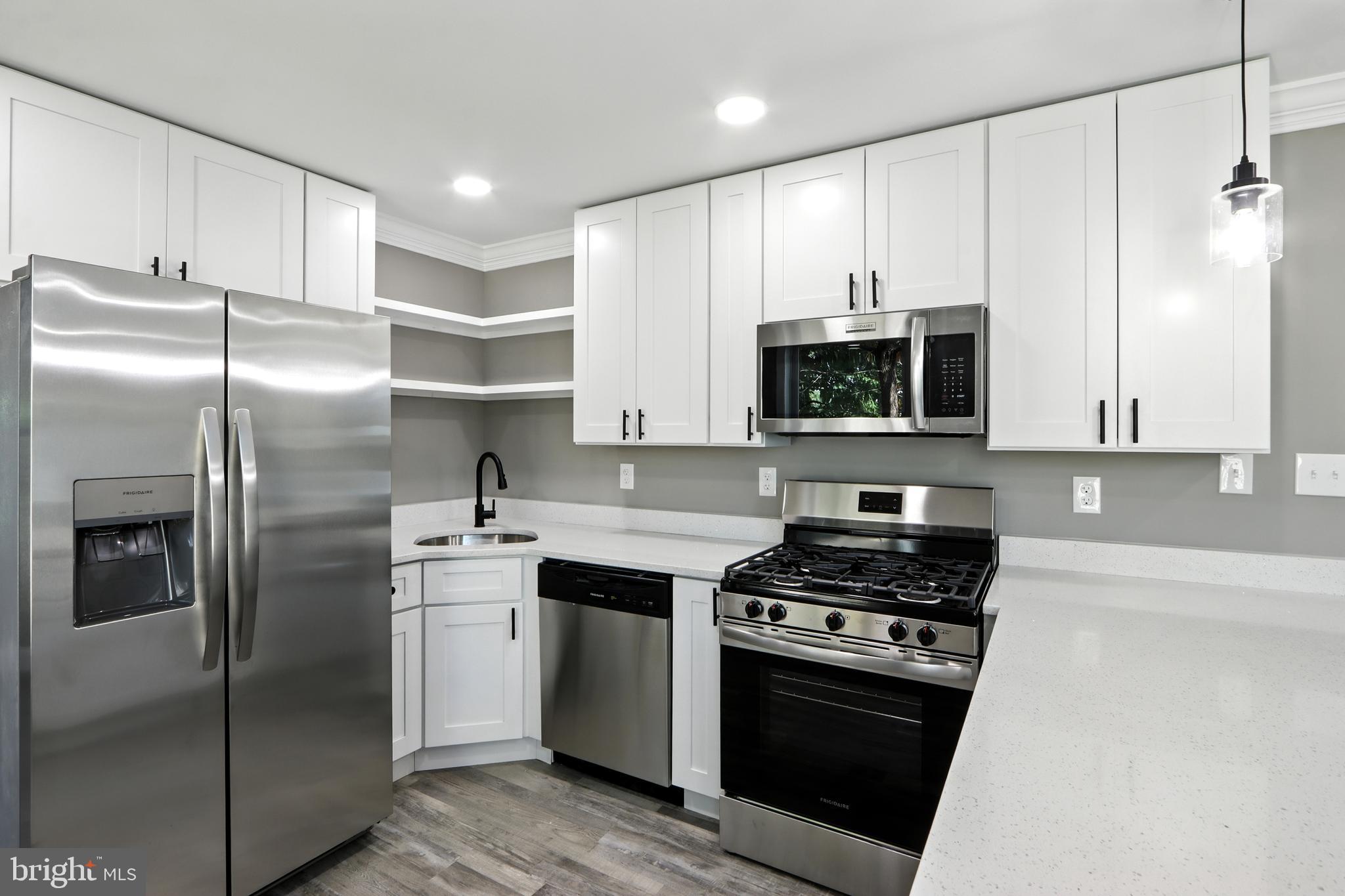 310 Audrey Avenue Baltimore, MD 21225 - Photo 11 of 35 a kitchen with stainless steel appliances granite countertop a stove a refrigerator and a microwave