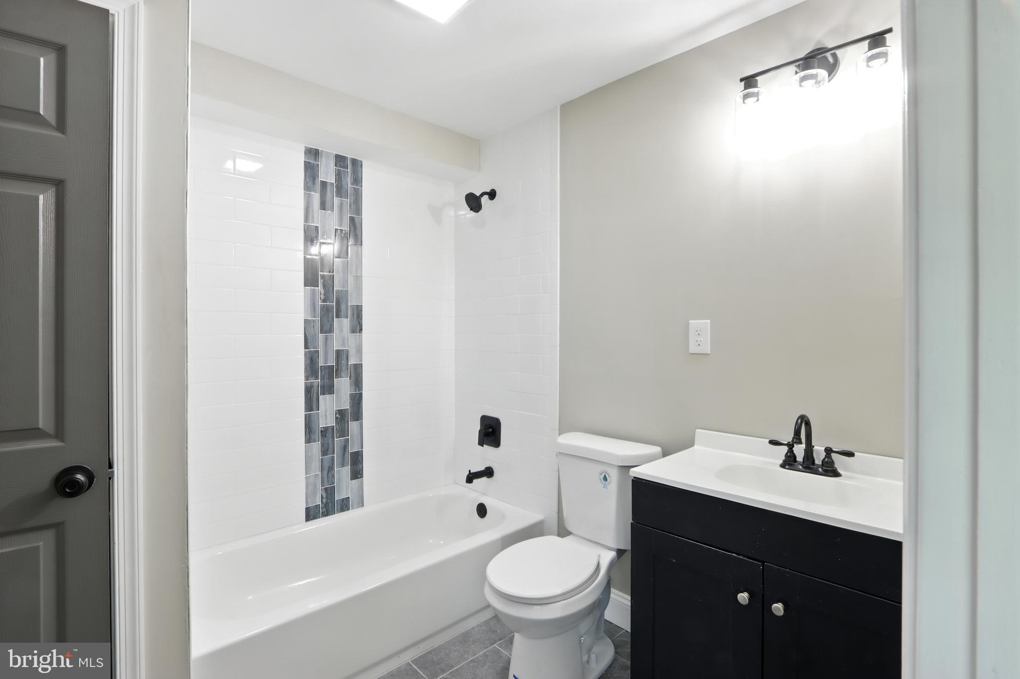 310 Audrey Avenue Baltimore, MD 21225 - Photo 19 of 35 a bathroom with a sink a toilet and shower