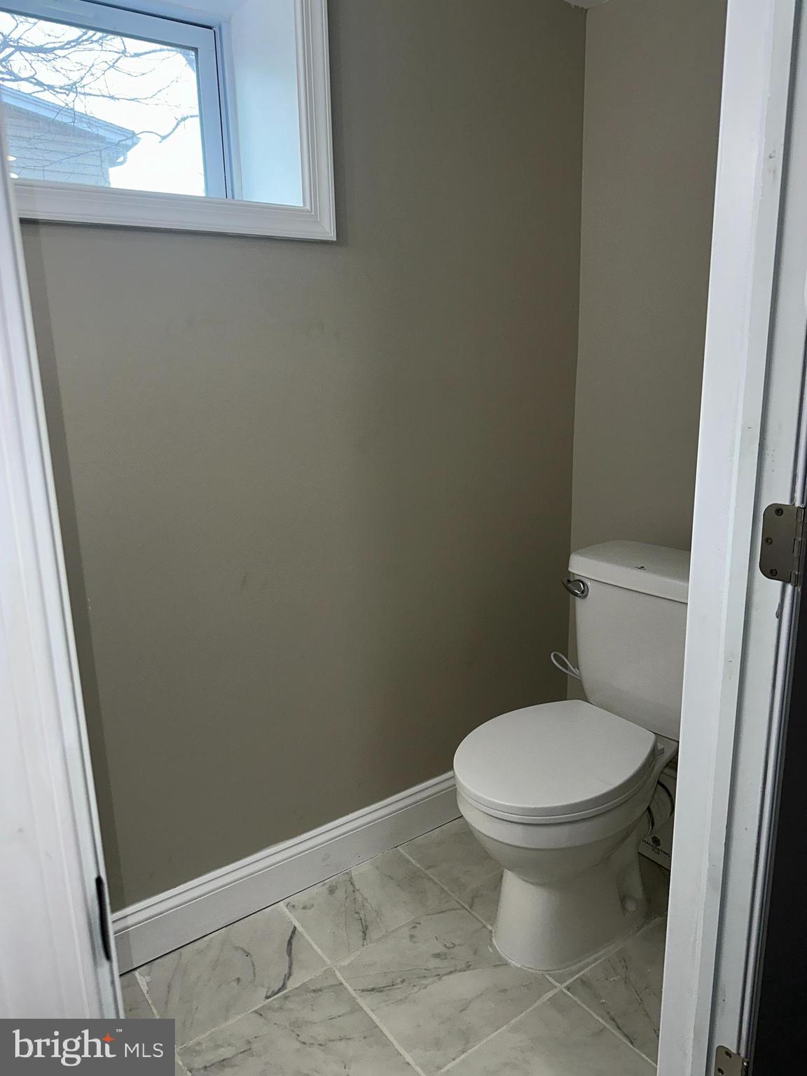 310 Audrey Avenue Baltimore, MD 21225 - Photo 30 of 35 a white toilet sitting in a bathroom next to a window