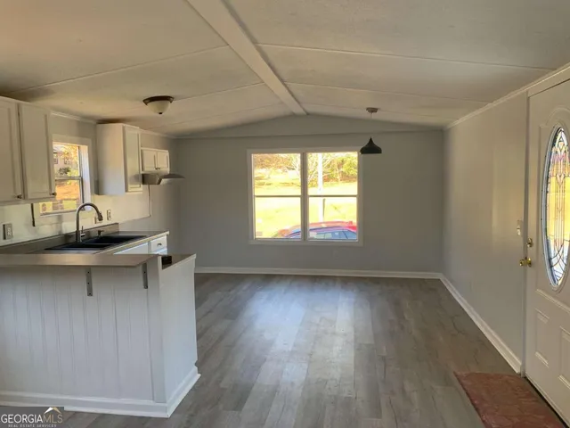a view of a kitchen and dining room with wooden floor