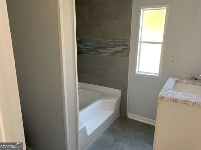 a bathroom with a tub and sink