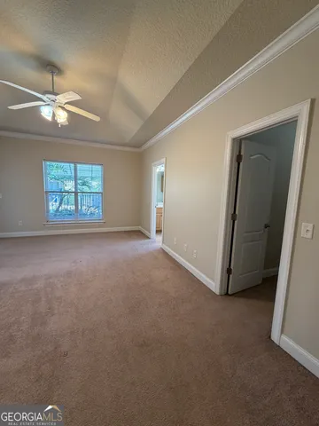 an empty room with windows and fan