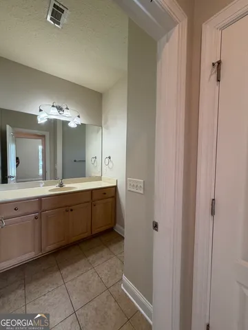 a large bathroom with a double vanity sink a mirror and a bathtub