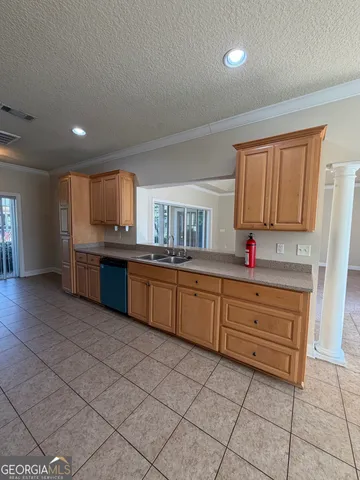 a kitchen with granite countertop a sink cabinets and stainless steel appliances