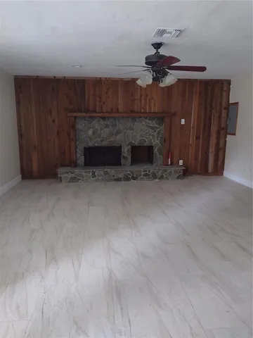 a view of a livingroom with a fireplace and a chandelier fan