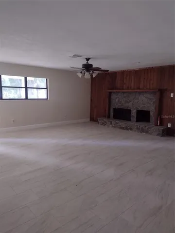 an empty room with windows and fireplace