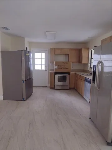 a kitchen with refrigerator and stove