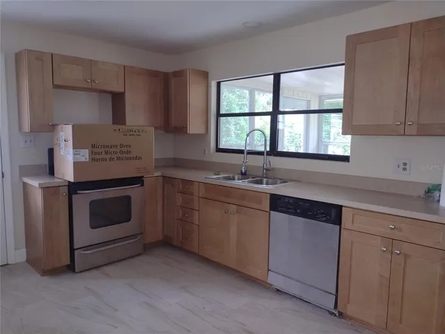 a kitchen with granite countertop white cabinets and a sink
