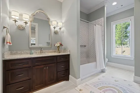a spacious bathroom with a granite countertop sink a mirror and a shower
