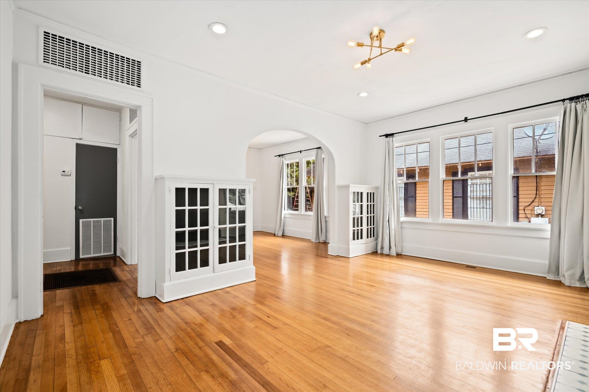 308 South Ann Street Mobile, AL 36604 - Photo 3 of 30 Unfurnished living room featuring a notable chandelier and light hardwood / wood-style floors