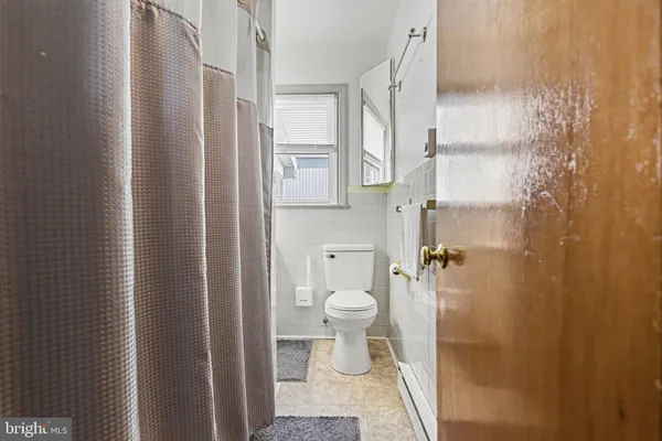 a bathroom with a granite countertop shower and a toilet