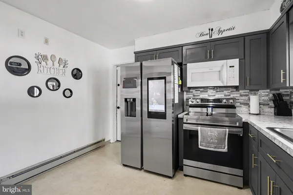a kitchen with stainless steel appliances granite countertop a refrigerator and a stove