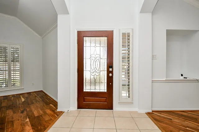 a view of an empty room with wooden floor and a fireplace