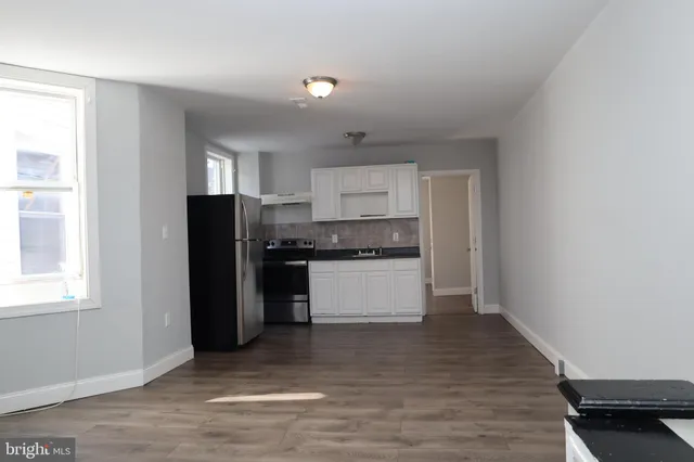 a kitchen with granite countertop a refrigerator and a stove top oven