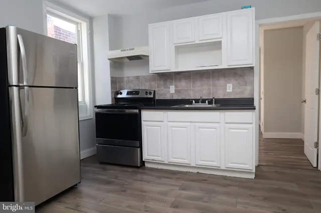 a kitchen with granite countertop white cabinets and stainless steel appliances