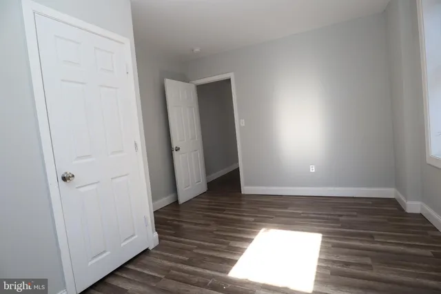 a view of a hallway with wooden floor and closet