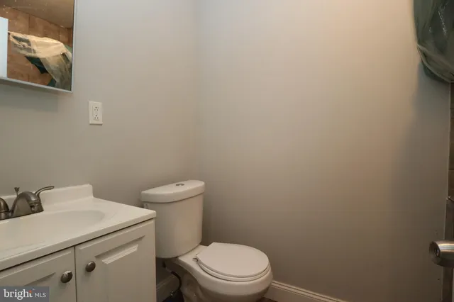 a white toilet sitting next to a white sink and vanity