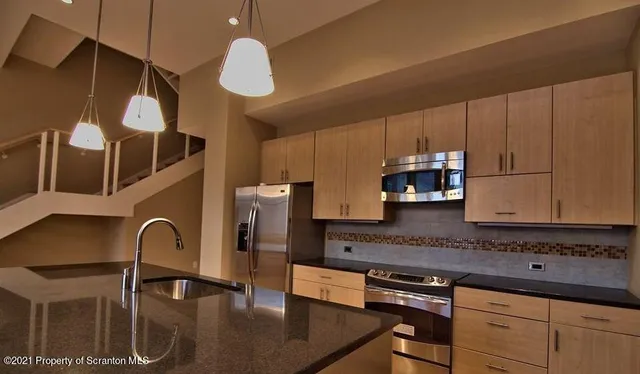 a kitchen with stainless steel appliances granite countertop a sink a stove and cabinets