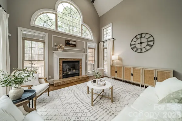 a living room with furniture a fireplace and a large window