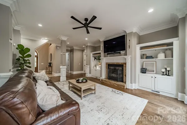 a living room with furniture a flat screen tv and a fireplace