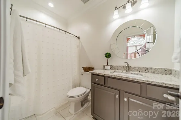 a bathroom with a granite countertop sink a toilet and a mirror