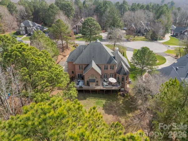 a view of a house with a yard and a large tree