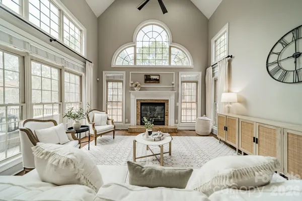 a living room with furniture a fireplace and a large window