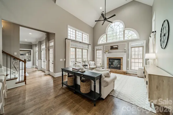 a living room with furniture a fireplace and a chandelier
