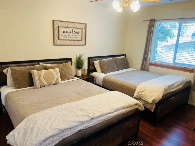 a bedroom with two beds and wooden floor