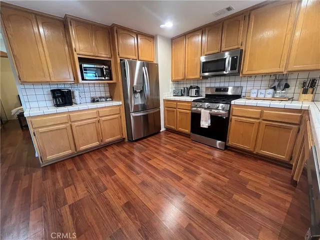 a kitchen with stainless steel appliances a refrigerator sink and microwave