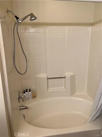 a bathroom with a white bath tub and a sink