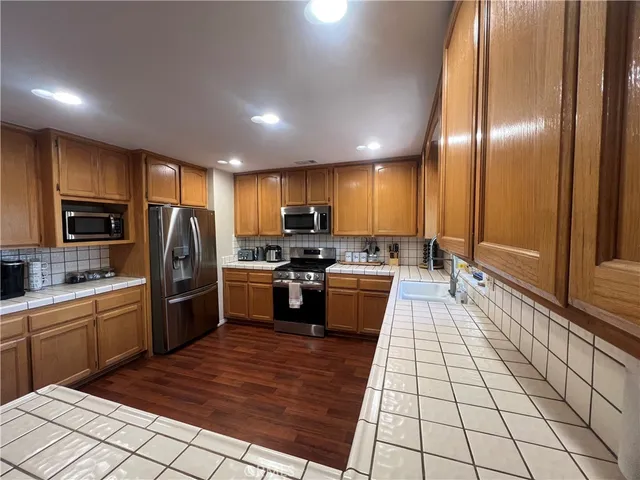 a large kitchen with granite countertop lots of counter top space and stainless steel appliances