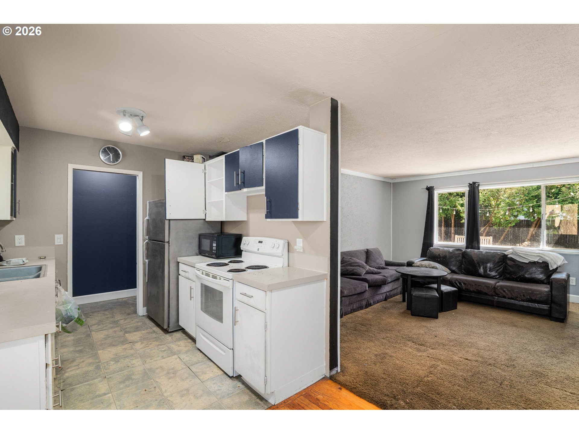 13670 Southwest 21st Street Beaverton, OR 97008 - Photo 6 of 26 a kitchen with stainless steel appliances kitchen island granite countertop a refrigerator a stove and a sink with granite countertops