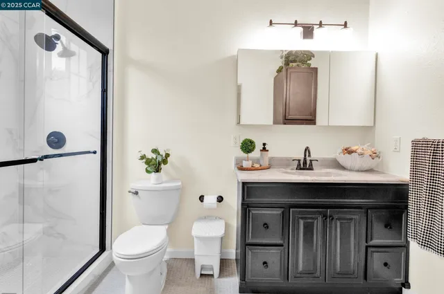 a bathroom with a granite countertop sink a toilet and a mirror