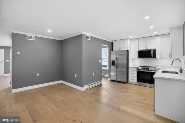 a view of a kitchen with a sink and a refrigerator