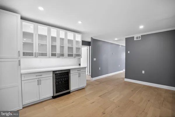a view of an empty room with a kitchen and a window