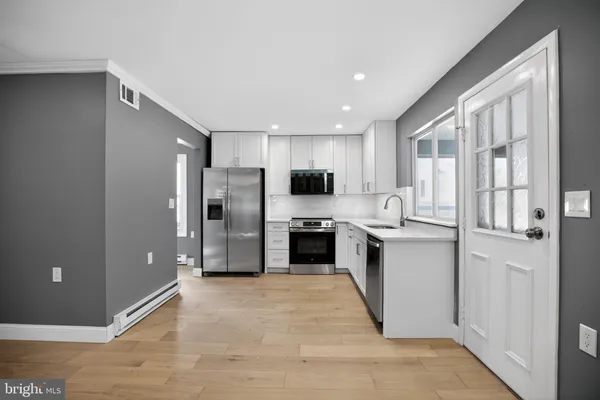 a kitchen with stainless steel appliances granite countertop a refrigerator and a sink