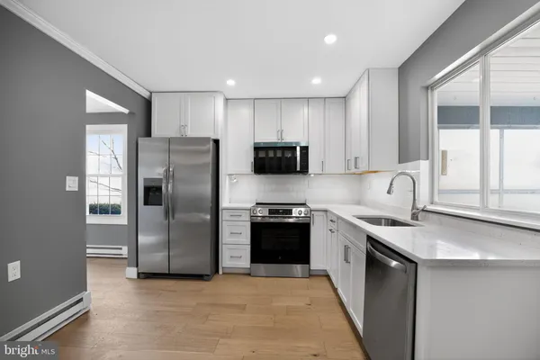 a kitchen with stainless steel appliances granite countertop a refrigerator sink and stove