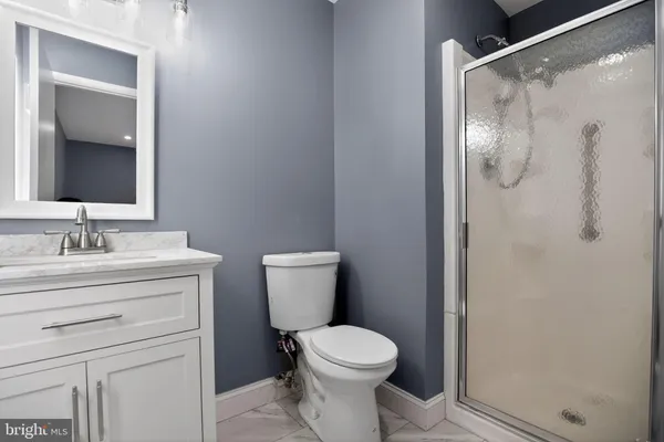 a bathroom with a granite countertop sink toilet and shower