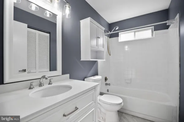 a bathroom with a sink toilet a mirror and shower