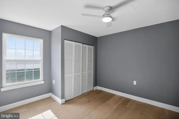 an empty room with windows and fan