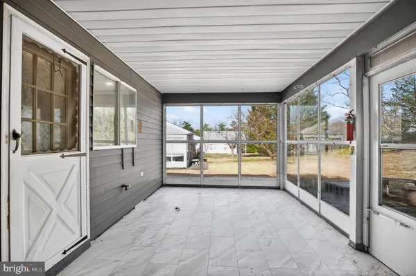 a view of an empty room with wooden floor and a balcony