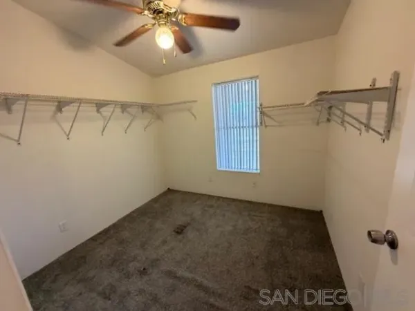 a view of a room with a ceiling fan and a rug