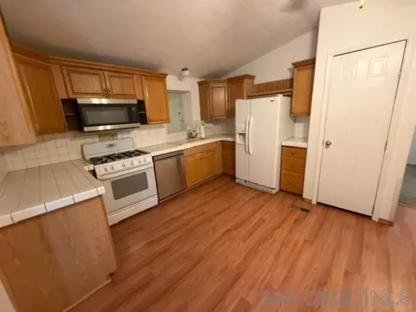 a kitchen with wooden floors and stainless steel appliances
