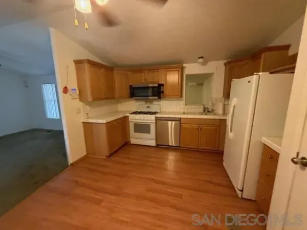 a kitchen with stainless steel appliances a refrigerator sink and microwave