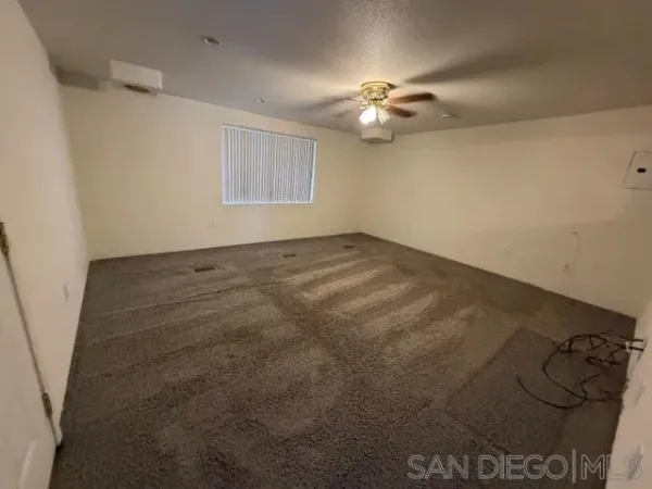 an empty room with a chandelier fan