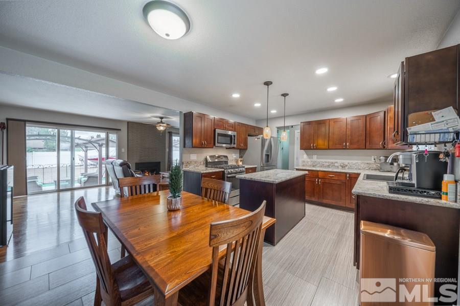 1640 Davidson Way Reno, NV 89509 - Photo 6 of 25 a dining room with stainless steel appliances kitchen island granite countertop a table chairs and a refrigerator
