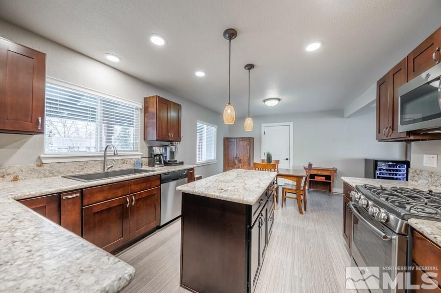 1640 Davidson Way Reno, NV 89509 - Photo 7 of 25 a kitchen with stainless steel appliances granite countertop wooden cabinets a sink dishwasher a stove and a refrigerator with wooden floor