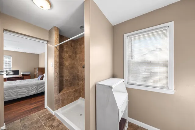 a bathroom with a granite countertop sink vanity mirror and a window